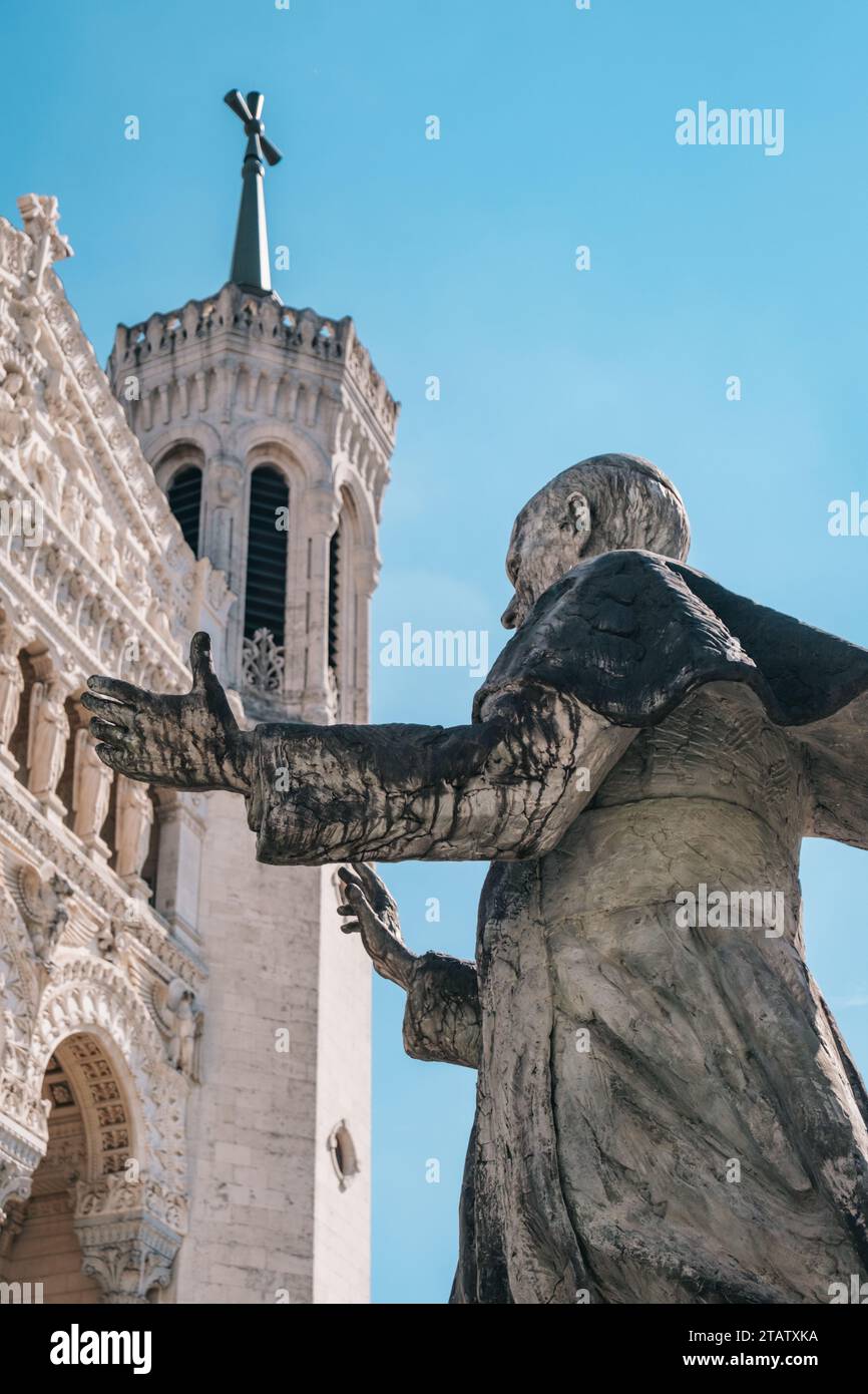 La statua di Papa Giovanni Paolo II di fronte alla facciata bianca neo-bizantina della basilica di Notre-Dame de Fourvière a Lione (Francia) Foto Stock