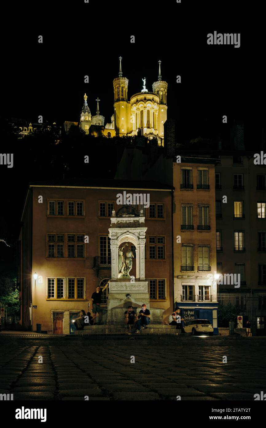 Vista notturna della basilica Fourviere da piazza Saint Jean e dalla sua fontana situata nella Vieux Lyon, la città vecchia di Lione (Francia) Foto Stock