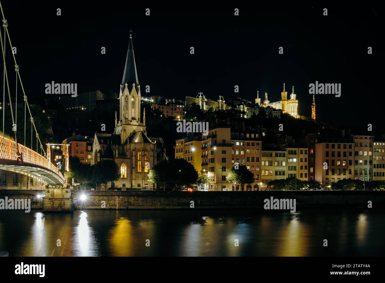 Vista notturna della chiesa di San Giorgio, del Quais de Saone e della basilica di Fourviere da un ponte pedonale sul fiume nella Vieux Lyon, la città vecchia di L Foto Stock