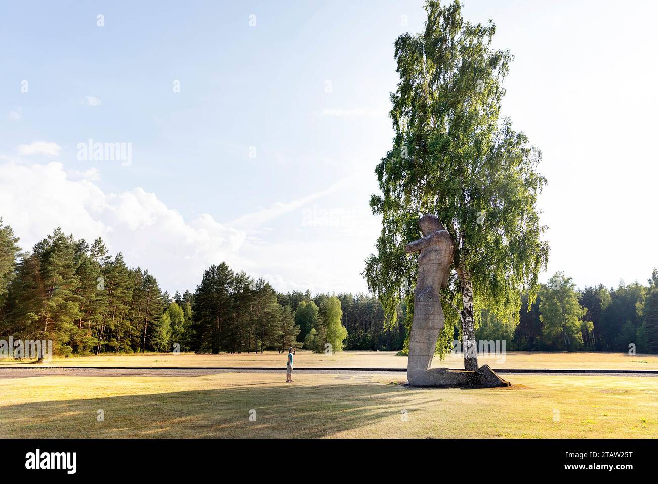 Turista che guarda la gigantesca scultura femminile al Salaspils Memorial, uno dei più grandi complessi monumentali d'Europa che commemorano le vittime del nazismo, in Lettonia Foto Stock