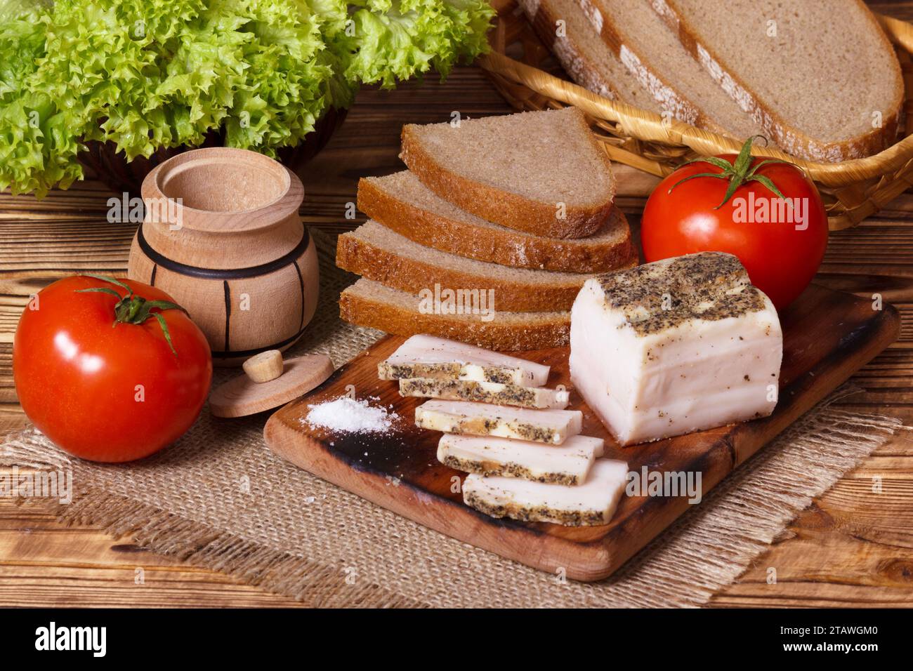Grasso salato di maiale con condimenti e verdure, colazione Ucraina tradizionale. Salo bianco o lardo a fette in stile rurale. Foto Stock