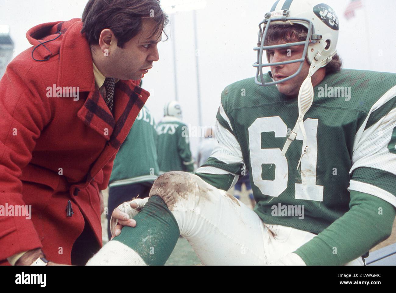 New York Jets ortopedico e medico di squadra Dr. Robert Grossman controlla la salute di un giocatore. Ai margini di una partita di football del 1978 allo Shea Stadium di New York. Grossman faceva parte dello staff dell'Institute of Sports Medicine and Athletic Trauma. L'atleta è John Roman, il lineman dei Jets. Foto Stock