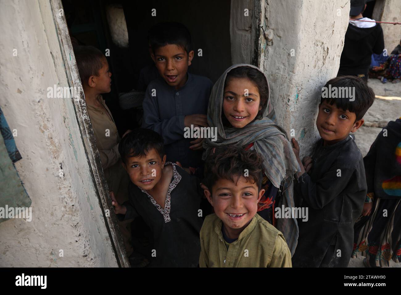 Felici bambini afghani in difficoltà, guardando la macchina fotografica e sorridendo. Foto Stock