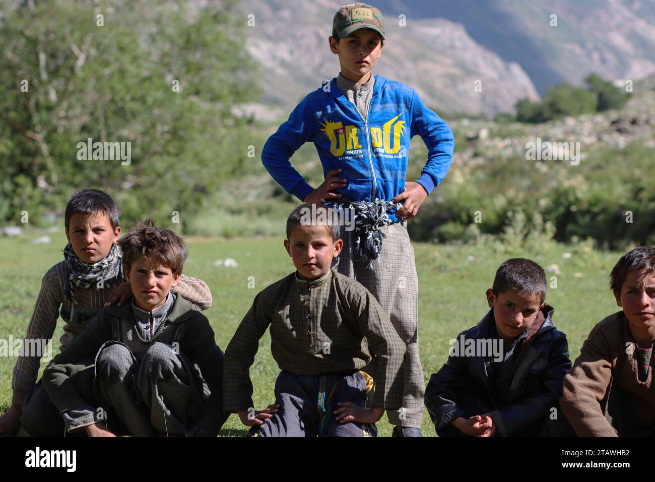 Felici bambini afghani in difficoltà, guardando la macchina fotografica e sorridendo. Foto Stock