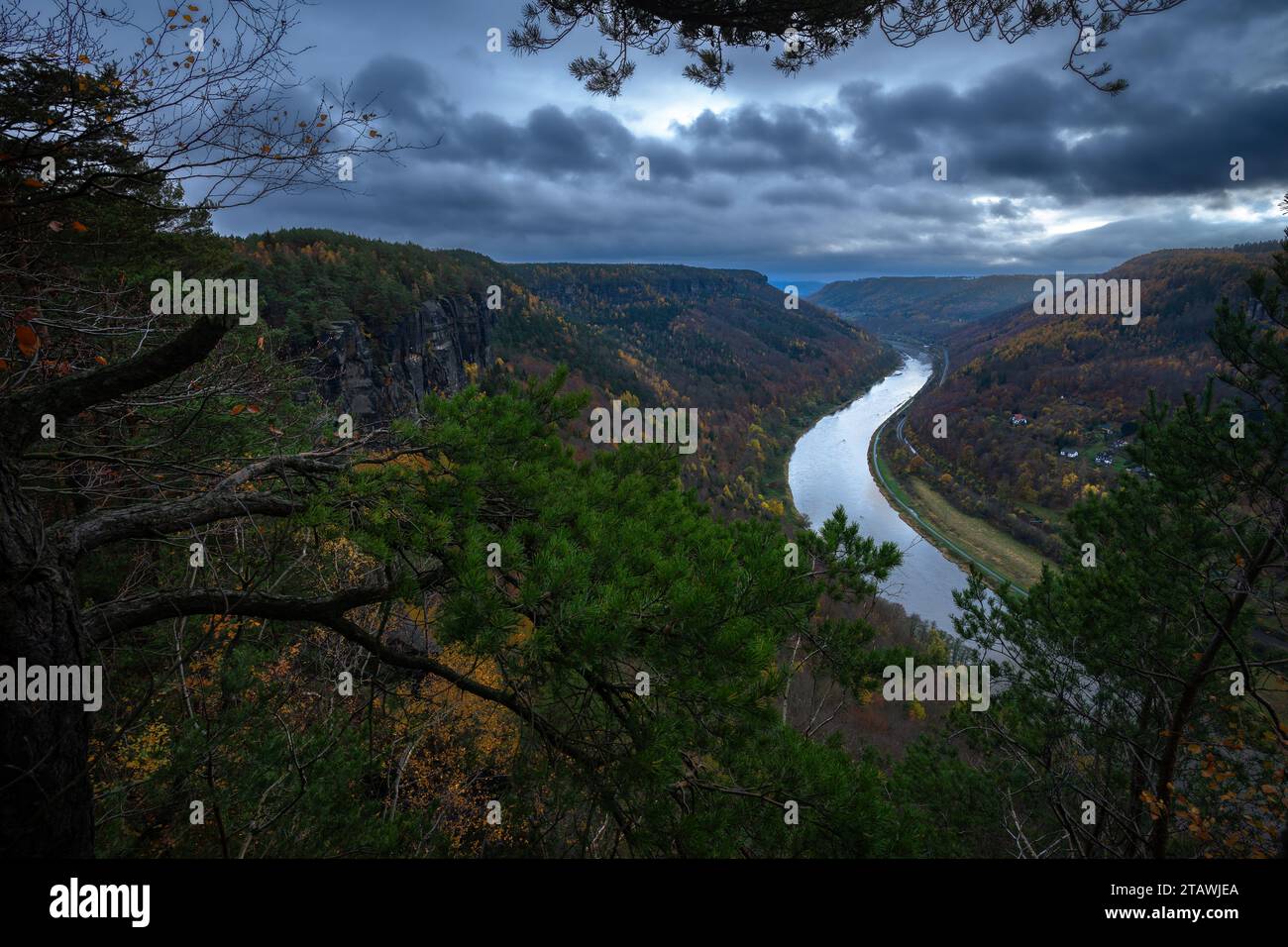 Ottima vista delle valli incredibilmente profonde e delle foreste scure con nuvole tempestose che si stagliano in alto in una serata elettrizzante. Foto Stock