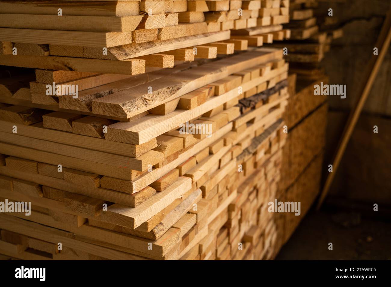 Tavole di legno grezze impilate che si asciugano nel magazzino del legname. Tavole di legno in primo piano. Sfondo delle tavole. Pila in legno di legno grezzo in legno costruttivo Foto Stock