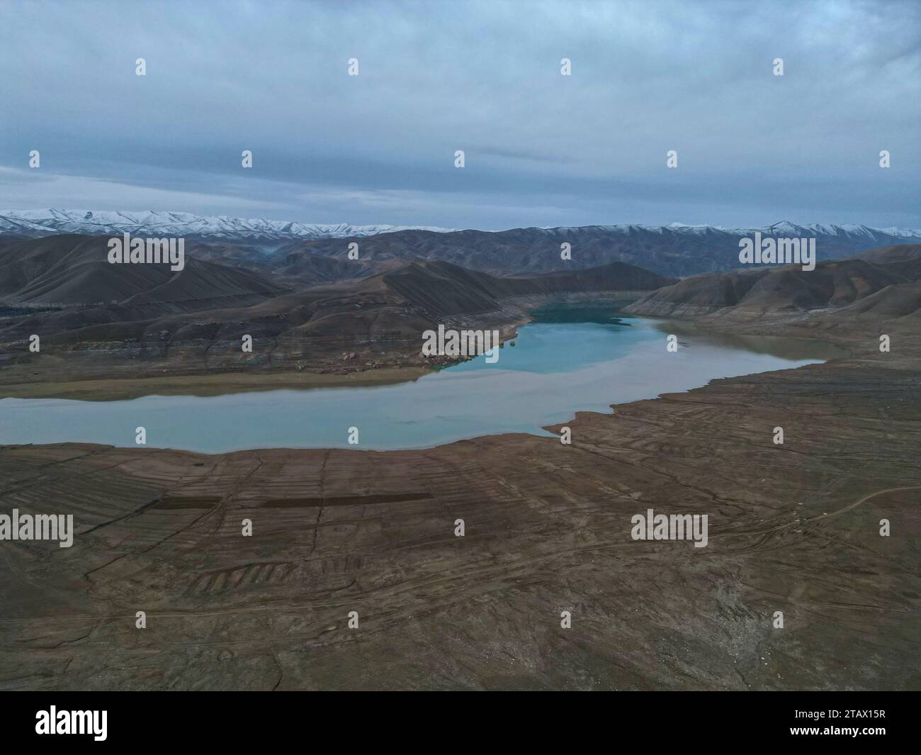 Un fiume che scorre attraverso un villaggio verde e montagne in Afghanistan Foto Stock