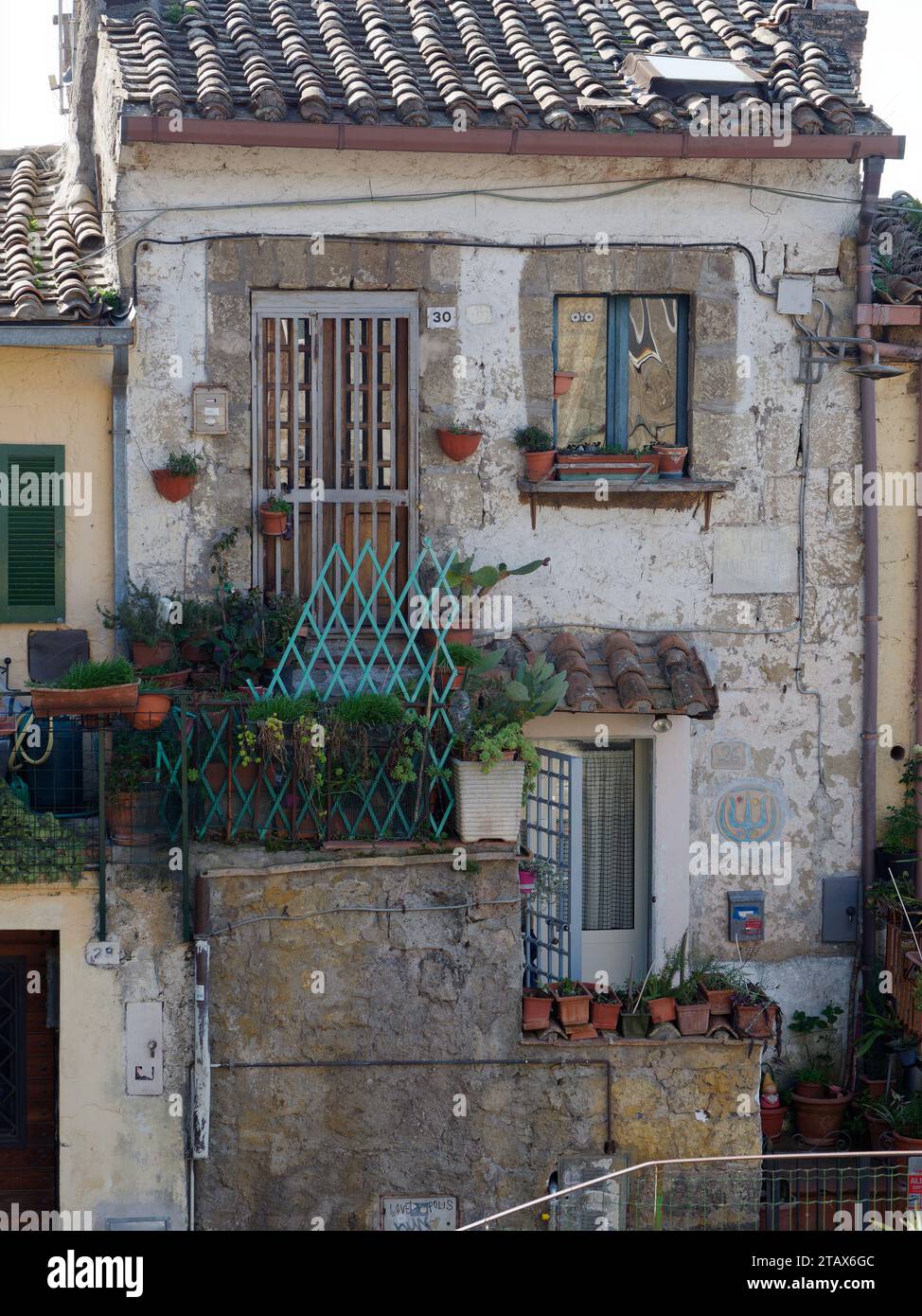 Pittoresca dimora storica con vasi di fiori e balcone nel comune di Calcata, regione Lazio, Italia, 3 dicembre 2023 Foto Stock