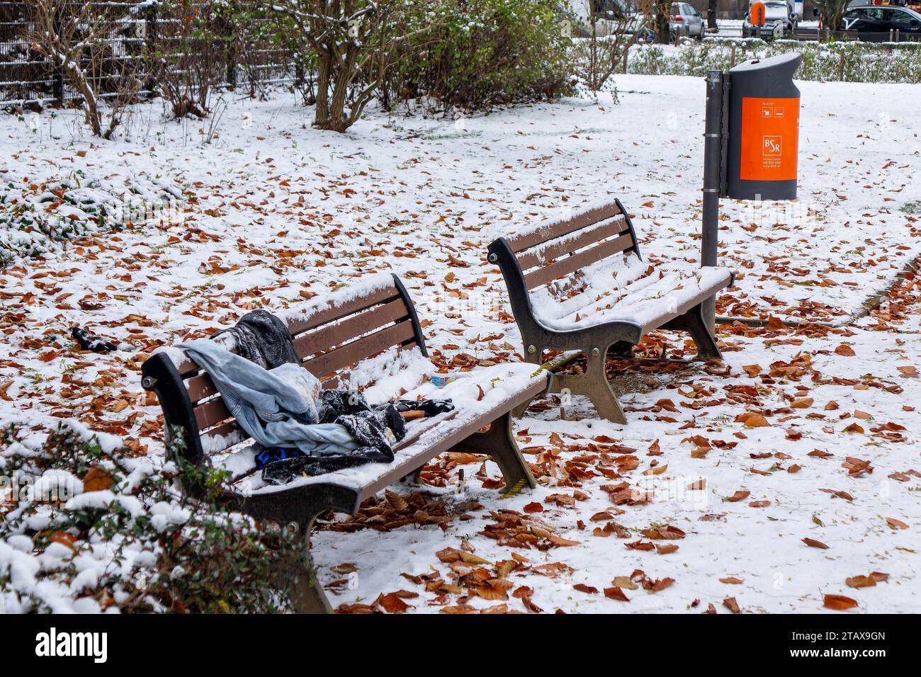 03.12.2023, Kleidungsstücke liegen auf einer schneebedeckten Parkbank. *** 03 12 2023, capi di abbigliamento sdraiati su una panchina del parco innevato credito: Imago/Alamy Live News Foto Stock