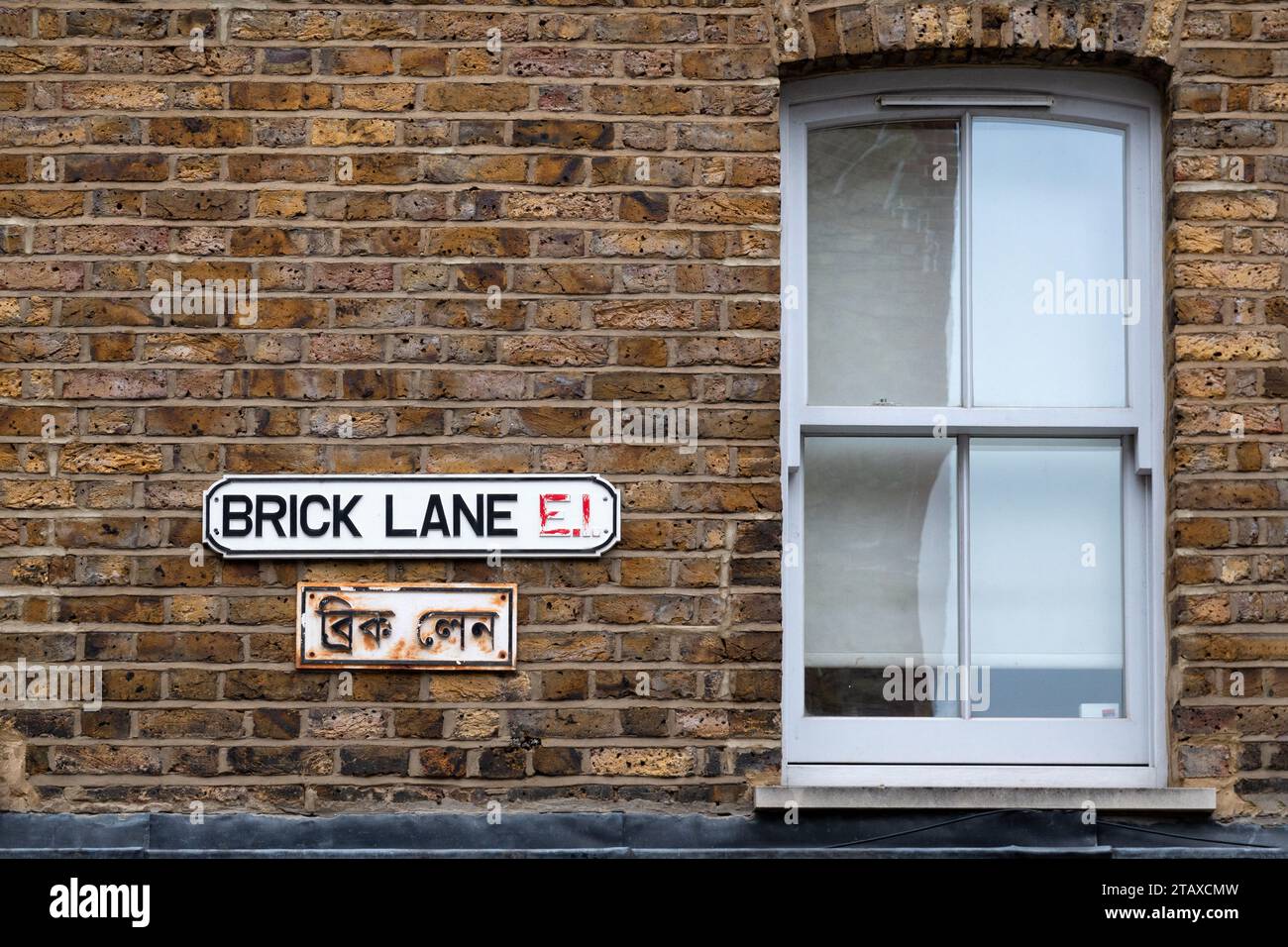 Una targa stradale per Brick Lane, E1, Londra. Sotto il cartello c'è un'altra targhetta con il nome della strada tradotto in Bengali Foto Stock