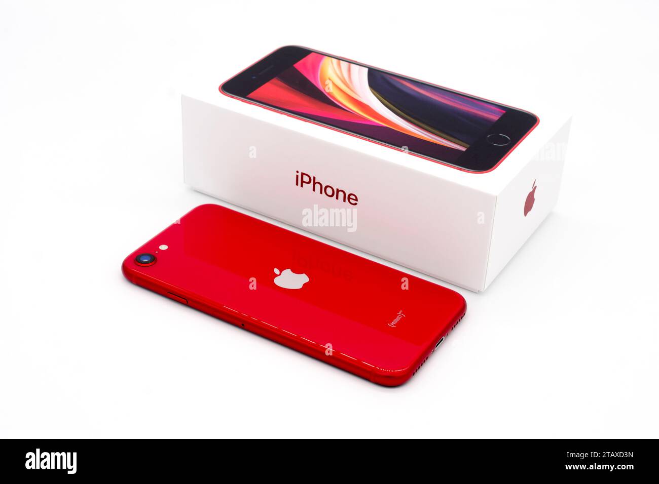 Apple iPhone se Second Edition accanto alla confezione con sfondo bianco. “Red Product” - vendita destinata al Fondo globale per combattere la COVID-19. Foto Stock