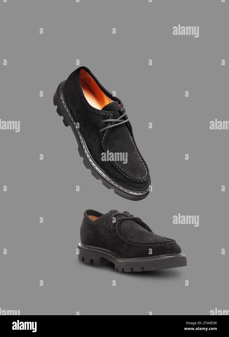 Scarpe in pelle scamosciata nera con lacci isolati su sfondo grigio Foto Stock