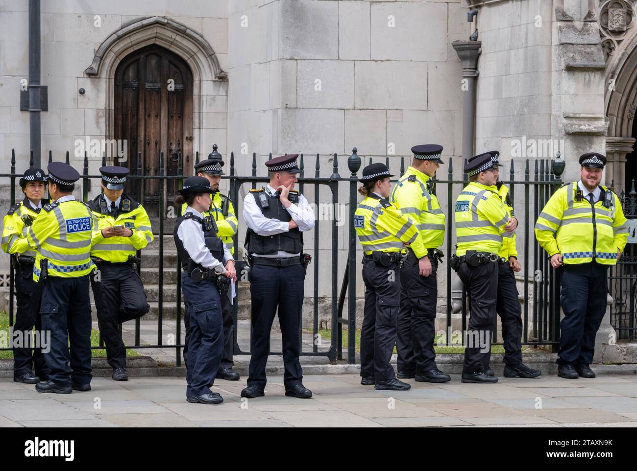 Agenti della polizia metropolitana in stand-by, con giacche ad alta visibilità, per accompagnare e monitorare una manifestazione di protesta in strada attraverso il centro di Londra Foto Stock