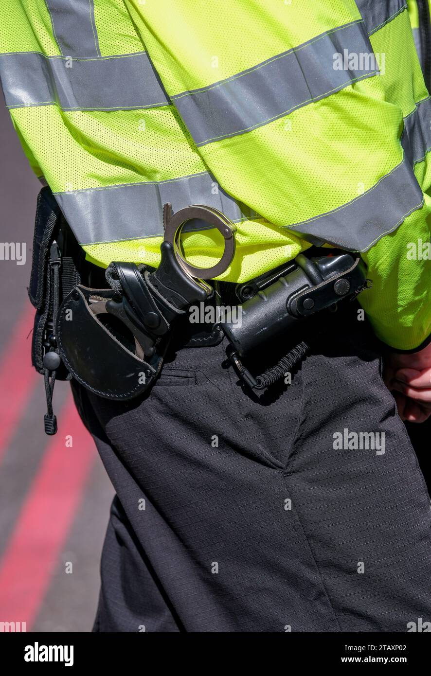 Agente della polizia metropolitana che indossa una giacca ad alta visibilità, con primo piano delle manette e sezione 5 spray al peperoncino, nel centro di Londra, Regno Unito. Foto Stock