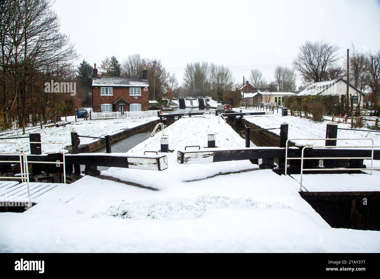 Cottage con canale chiuso sulla neve in inverno sul canale Trent e Mersey a Wheelock, Inghilterra, Regno Unito Foto Stock