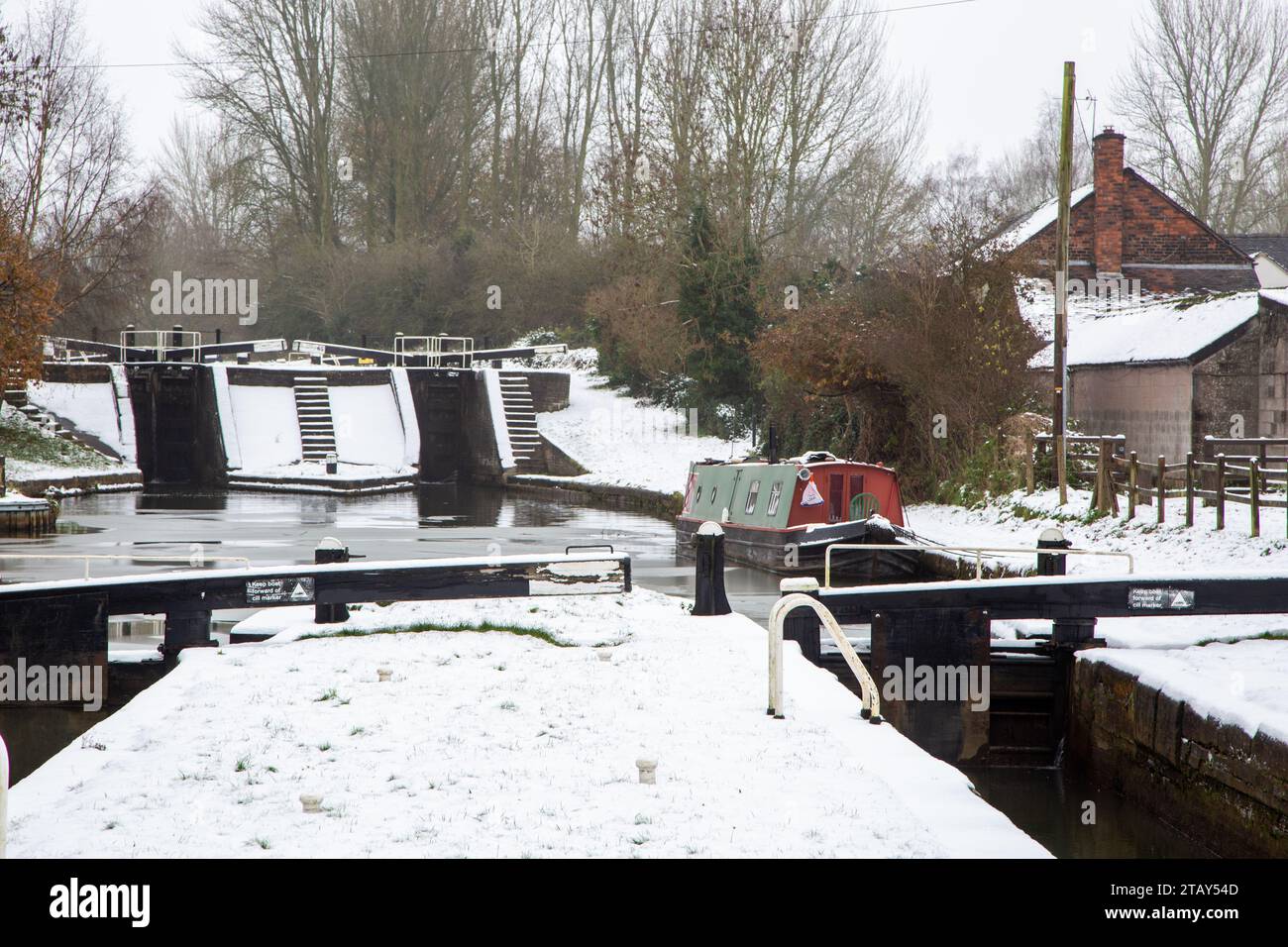 Canal narrowboat ormeggiato sul canale Trent e Mersey nella neve durante l'inverno a Wheelock Locks Cheshire Inghilterra Regno Unito Foto Stock