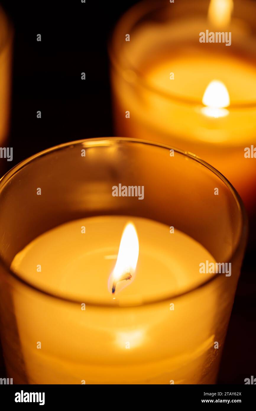 Candele aromatiche in vetro: Luce calda su sfondo scuro, primo piano Foto Stock