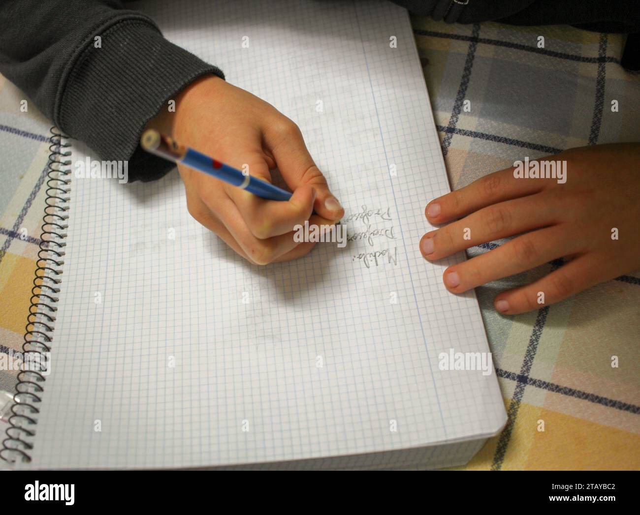 ragazzo che scrive per fare i compiti dopo la scuola Foto Stock