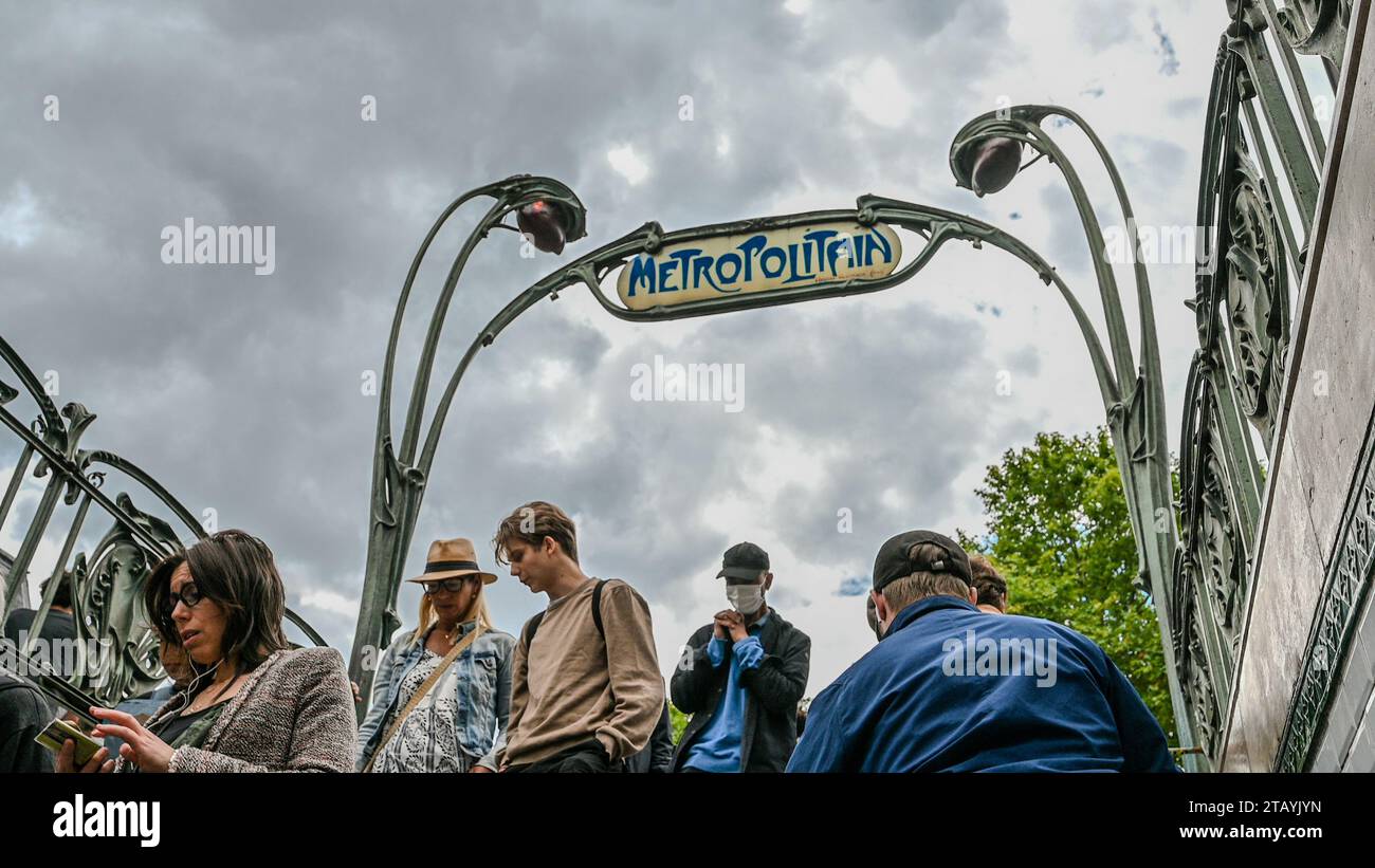 Parigi, Francia. 1° luglio 2022. Vita in città: La gente scende per le scale per accedere alla fermata della metropolitana. Sopra di loro il caratteristico segno vintage con una YE Foto Stock