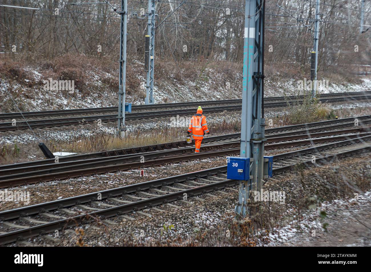 Varsavia, Mazowieckie, Polonia - 12.04.2023: Una persona che indossa una giacca arancione ad alta visibilità che esegue lavori di manutenzione sui binari ferroviari Foto Stock