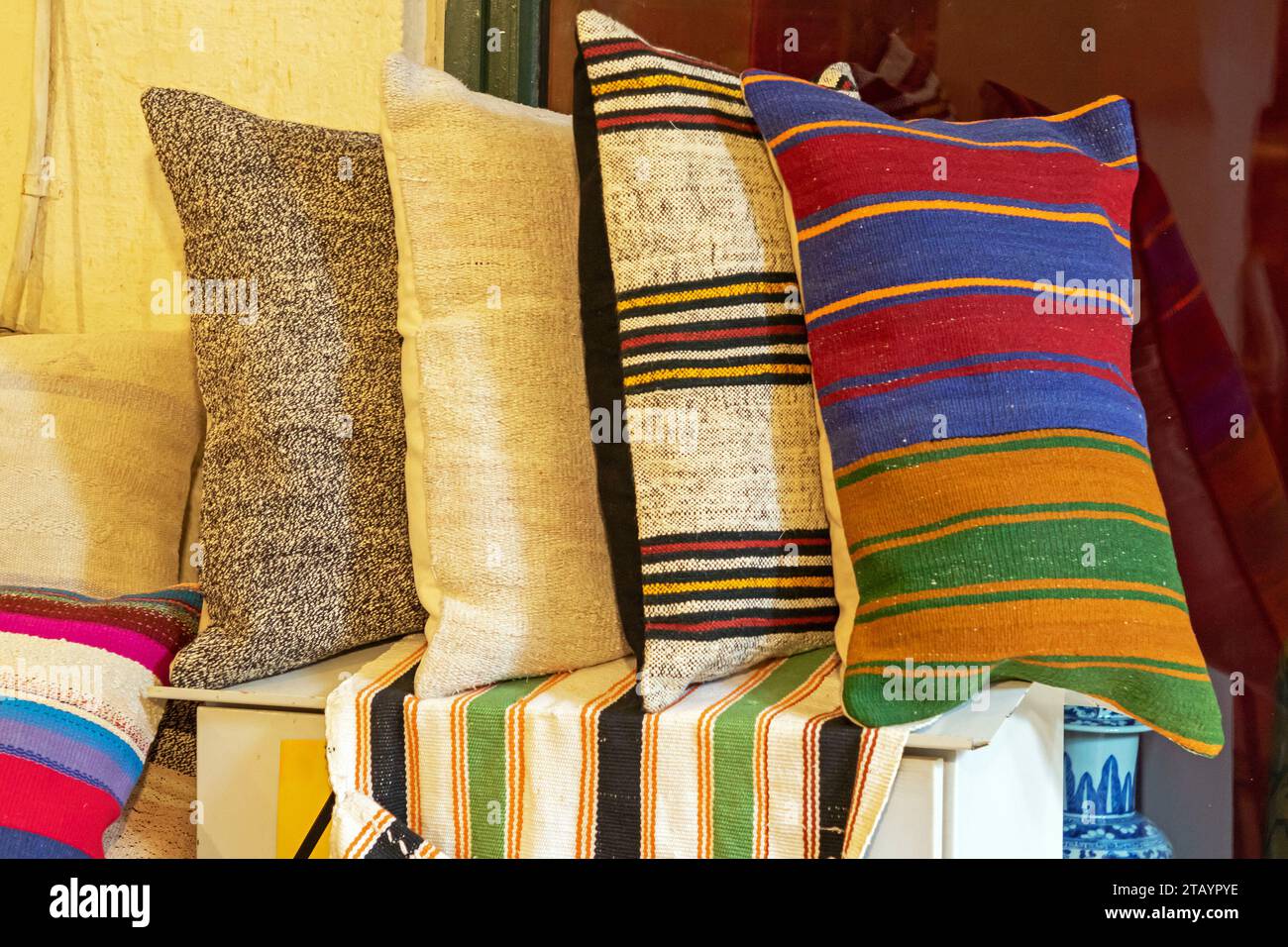 Cuscini decorativi in morbido tessuto colorato su un interno dello scaffale Foto Stock