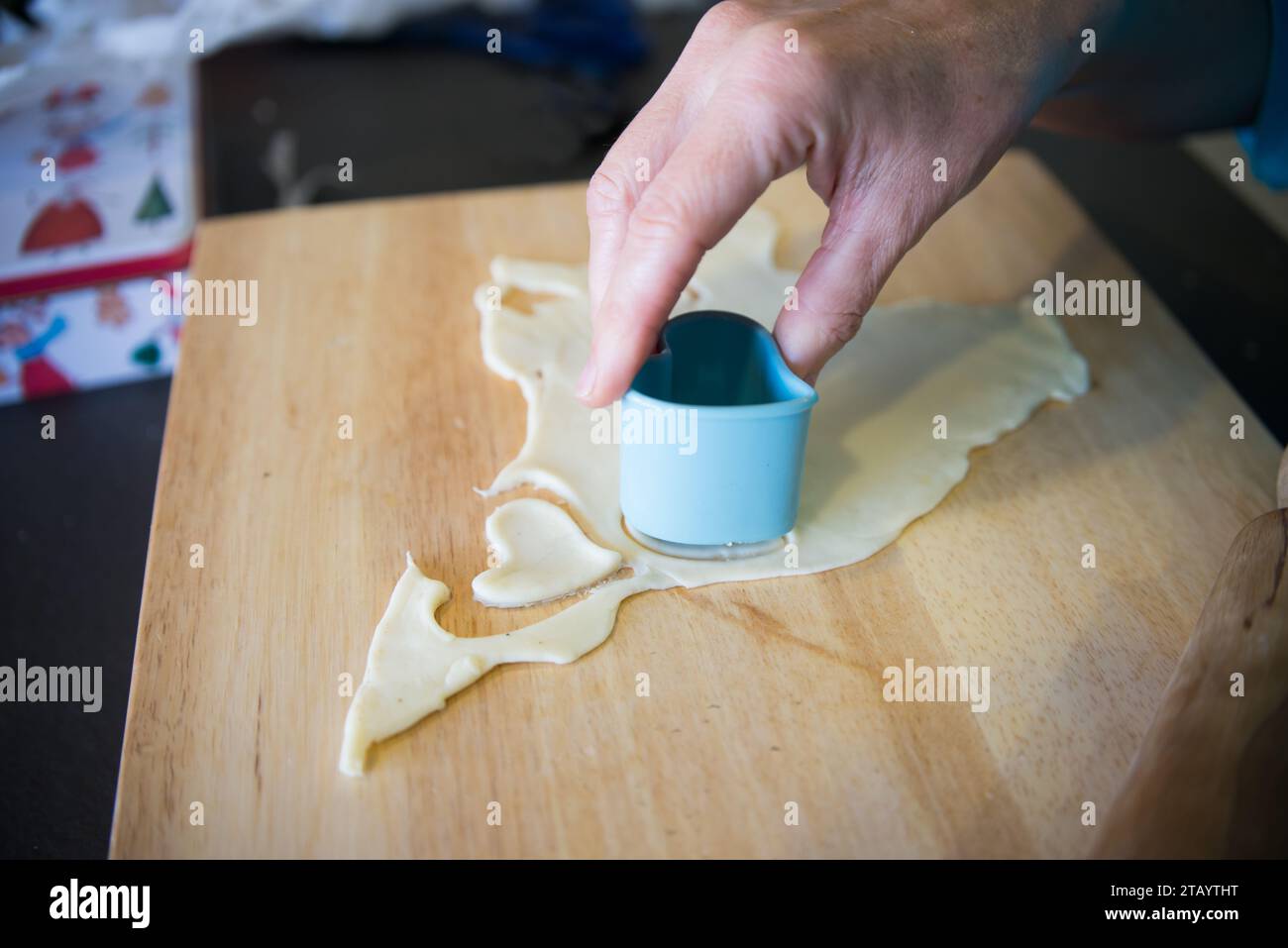 Donna che fa a mano biscotti a forma di cuore. Cucina domestica, Spagna Foto Stock