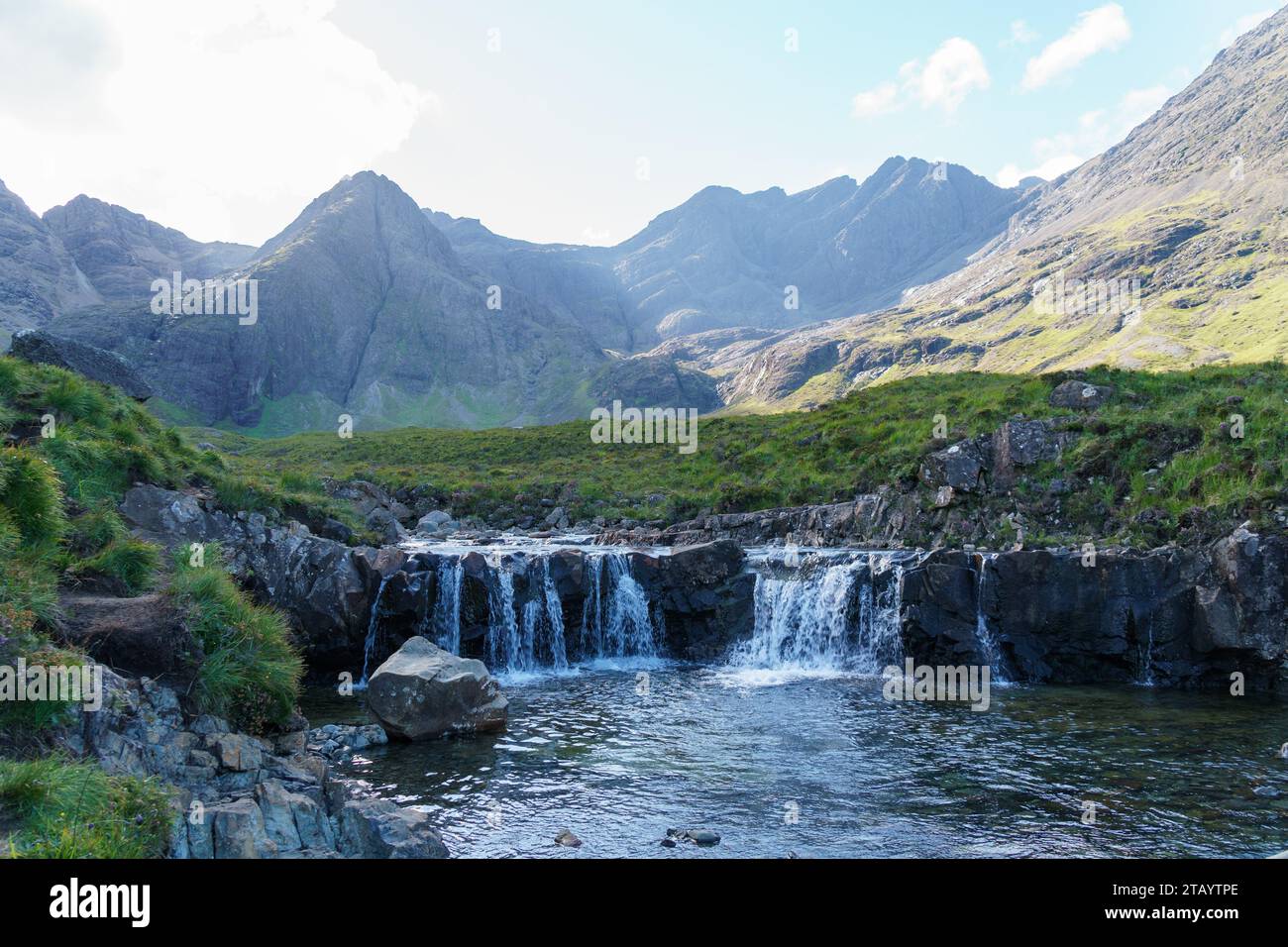Cascate di piscine favolose e montagne lontane nell'Isola di Sky in Scozia. Ampia vista delle cascate. Foto Stock