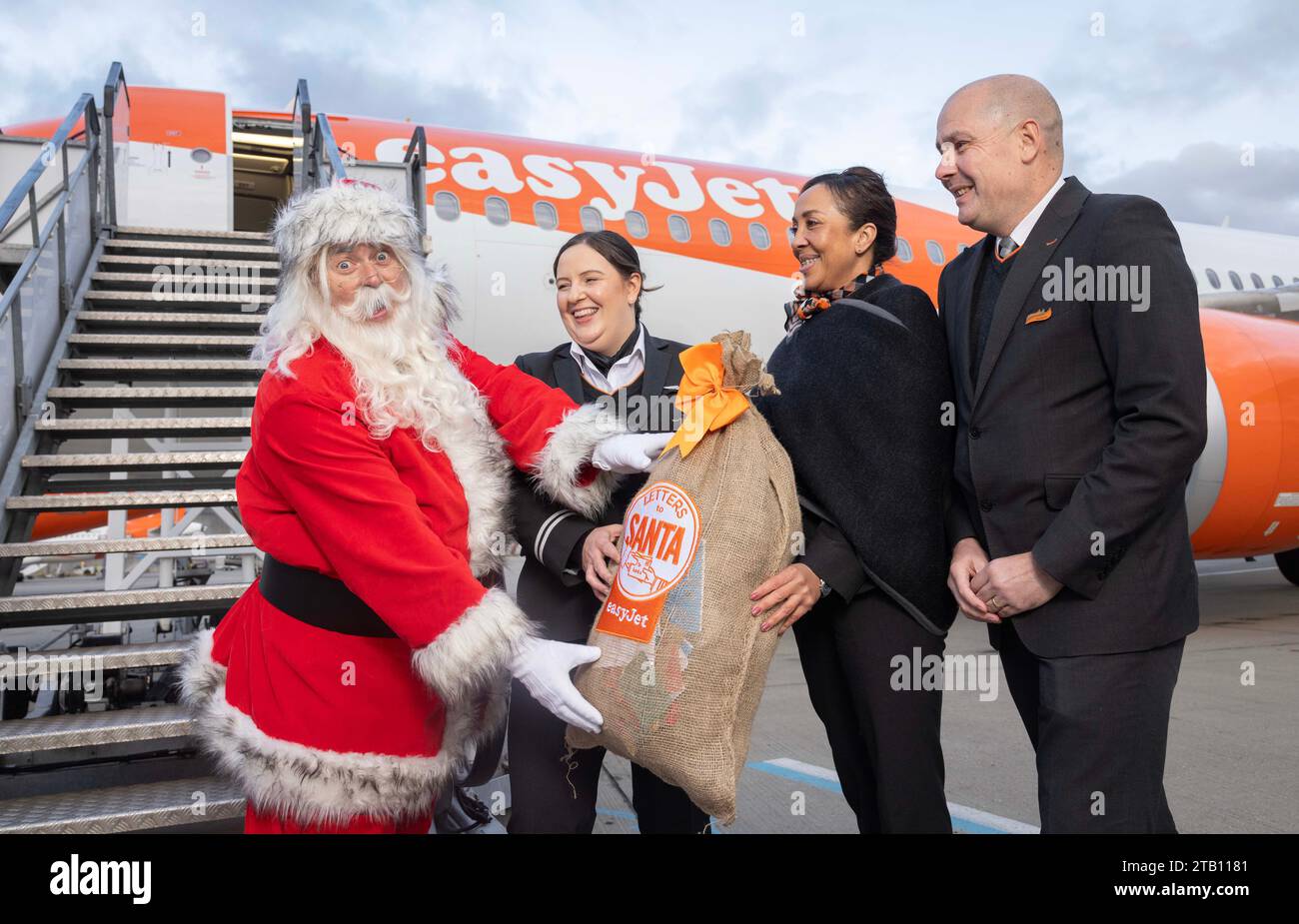 SOLO EDITORIALE (da sinistra a destra) Babbo Natale con il pilota easyJet Hannah Wells e la cabina Eva Lewis e Colin Young che consegnano le "lettere a Babbo Natale" per bambini su un volo easyJet per Rovaniemi in Lapponia, la casa di Babbo Natale, Londra. Data di emissione: Lunedì 4 dicembre 2023. Foto Stock