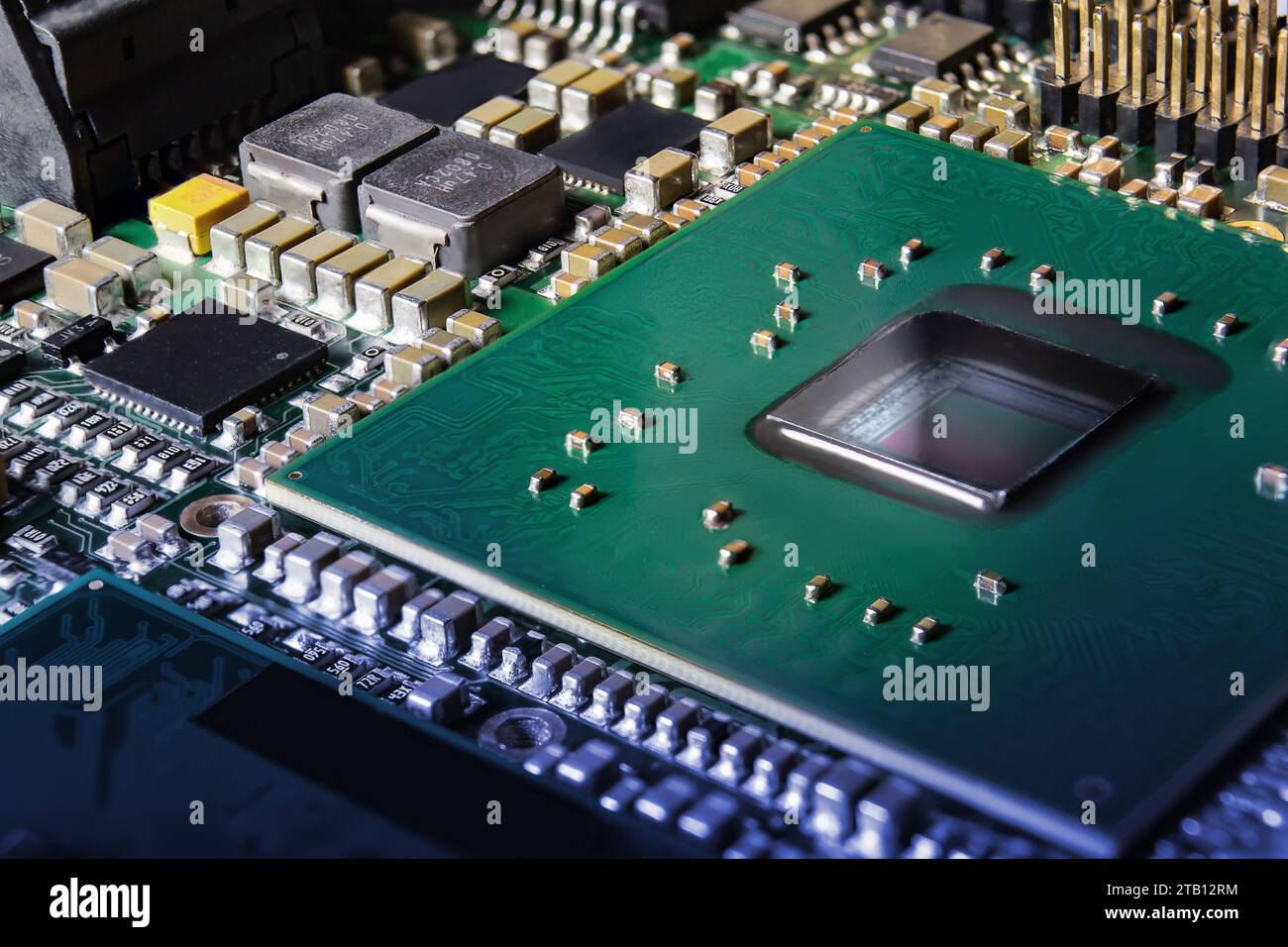 Primo piano sulla moderna scheda elettronica con processore, circuiti integrati e componenti passivi a montaggio superficiale. Background tecnologico Foto Stock