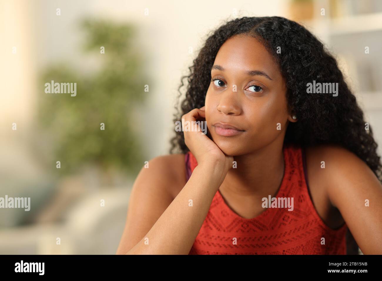 Ritratto di una donna nera seria a casa che ti guarda Foto Stock