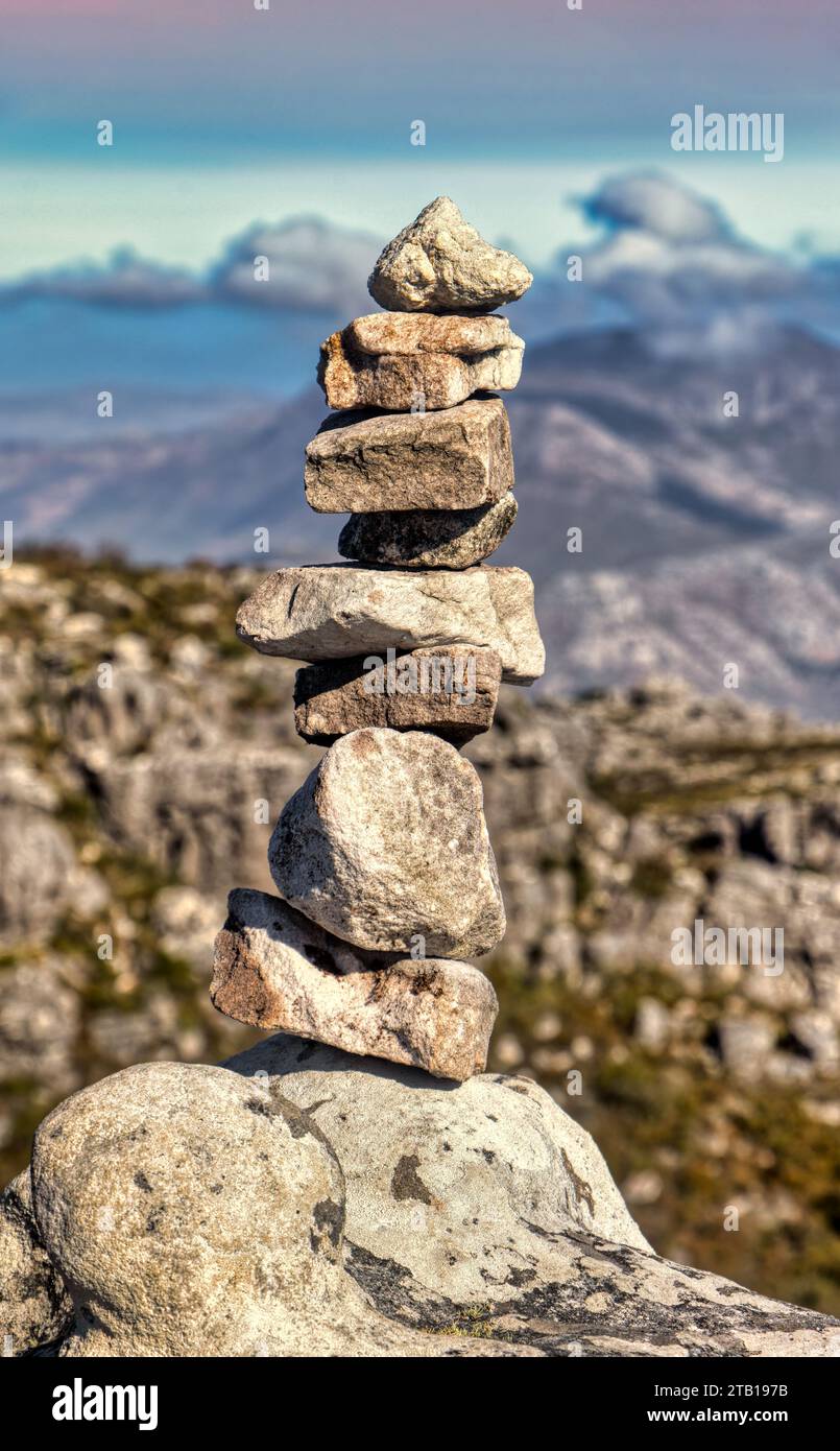 torre rocciosa composta da un mucchio di pietre zen, catena montuosa con sfondo nuvoloso Foto Stock
