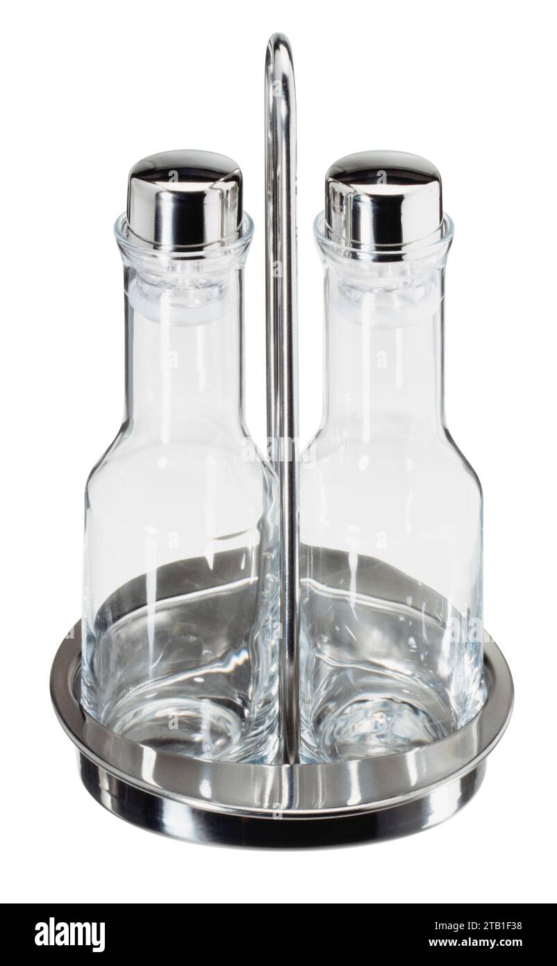 Set con due piccole bottiglie vuote per olio e aceto in un supporto metallico isolato sul retro bianco Foto Stock