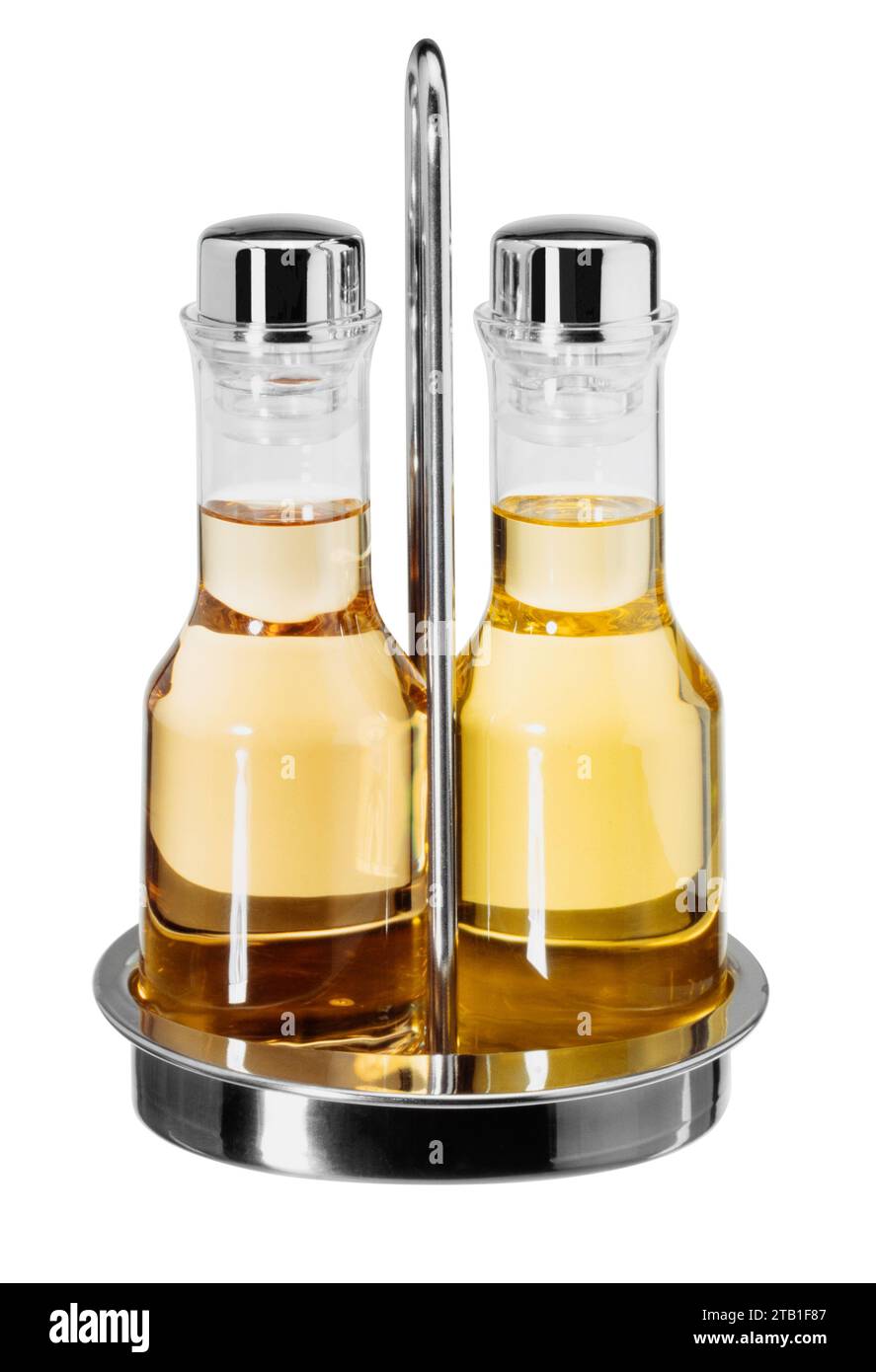 Set con due piccole bottiglie con olio e aceto in un supporto metallico isolato sul retro bianco Foto Stock