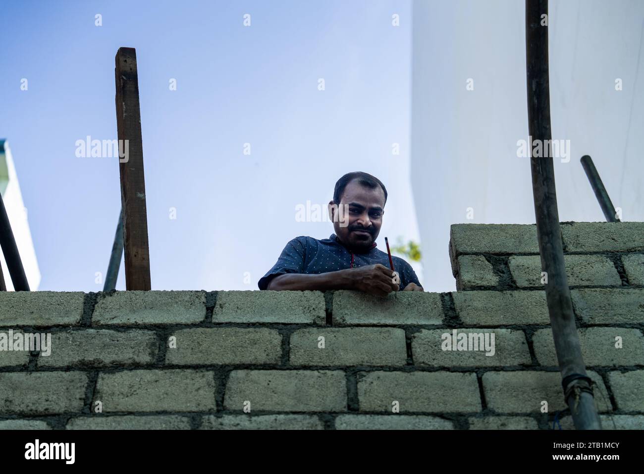 Maldive. 4 dicembre 2023. Un operaio costruisce un muro su una nuova casa in costruzione a Malé. Vita quotidiana a Malé, Maldive, la capitale dell'isola nazione nell'Oceano Indiano, la cui economia dipende fortemente dal turismo. La popolazione del paese comprende molti cittadini stranieri che lavorano da nazioni di tutto il mondo, tra cui Filippine, Myanmar, Sri Lanka e India, e la sua popolazione è prevalentemente musulmana. Crediti: Matt Hunt/Neato/Alamy Live News Foto Stock