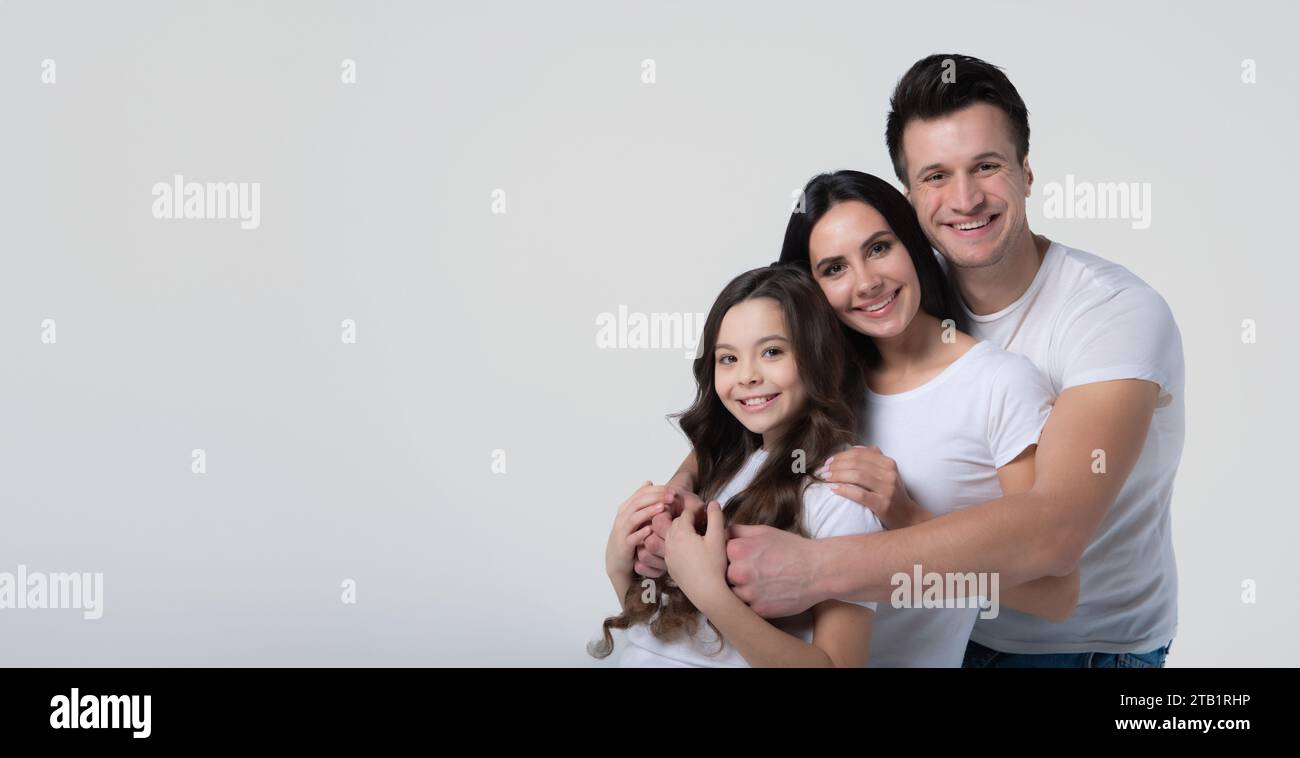 Foto ravvicinata di una bella e sorridente squadra di famiglia che si posa in una maglietta bianca mentre sono isolati su sfondo bianco in studio. Foto Stock