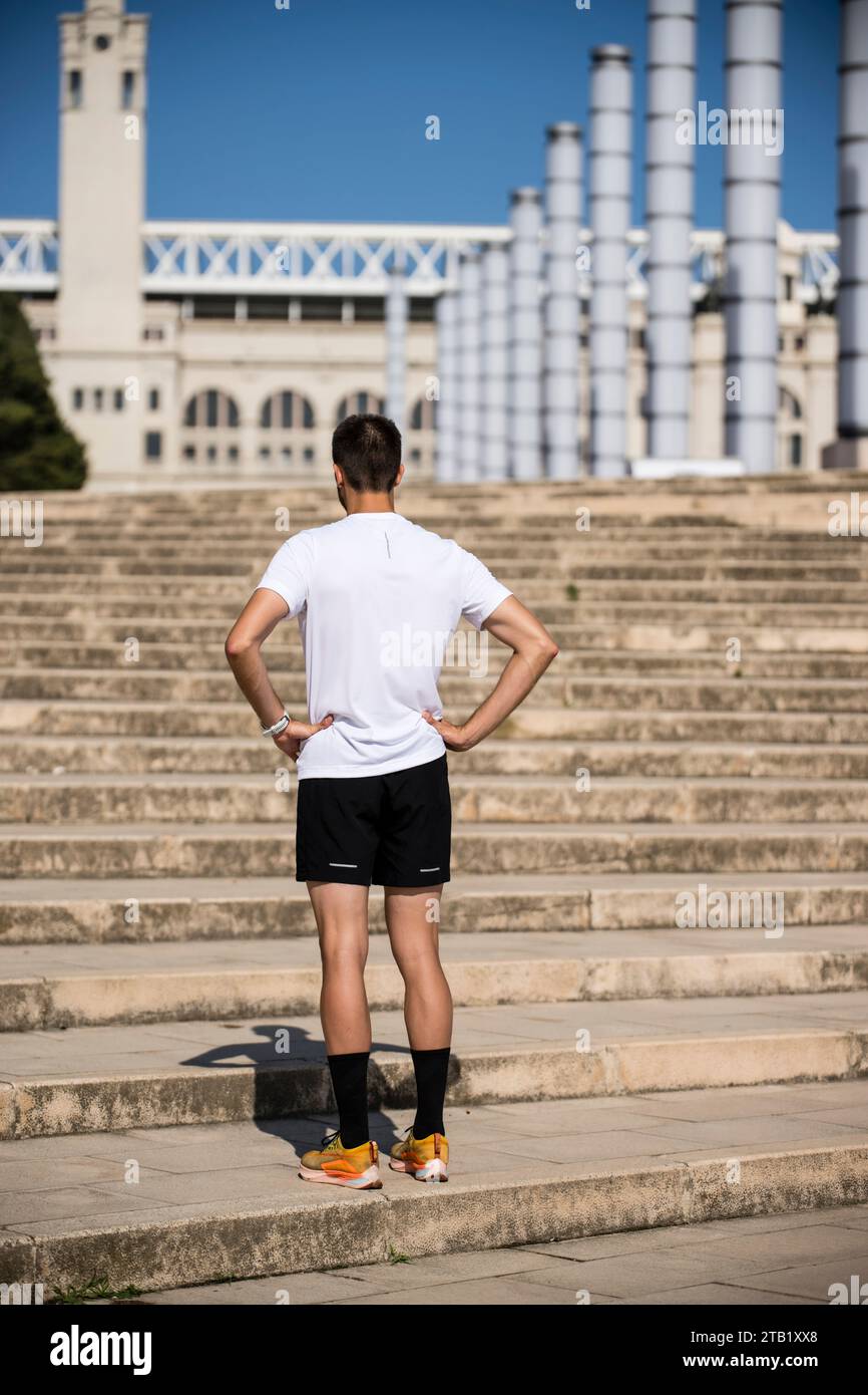 Vista posteriore dell'atleta maschile in piedi sulle scale all'esterno Foto Stock