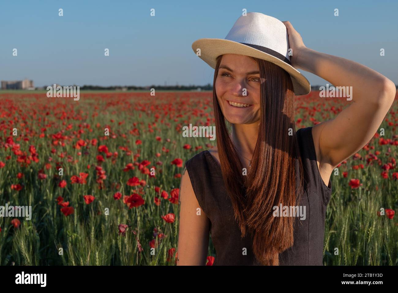Ritratto di Una giovane donna che ride in Un campo di papavero Foto Stock