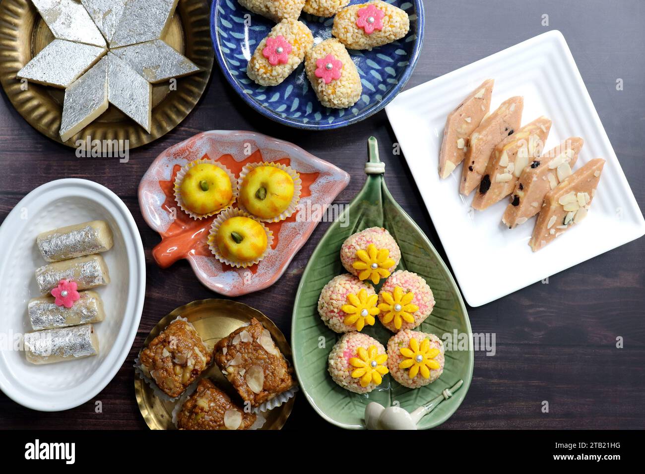 Assortimento indiano di dolci Diwali o mithai con diya e fiori. Idea regalo natalizia. Kaju katli, peda di frutta secca, barfi, barfi di anacardi, marzapane. Foto Stock