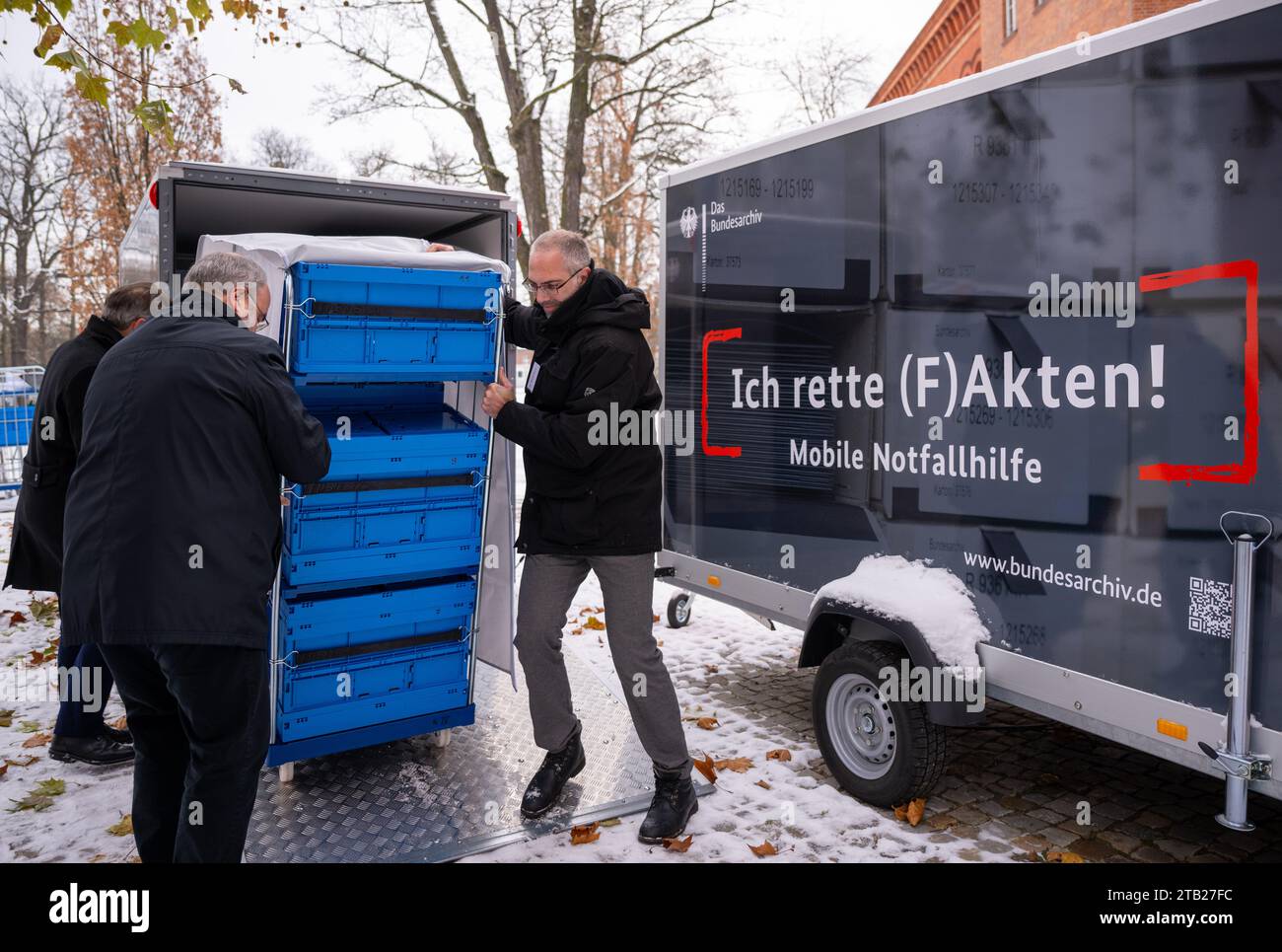 Berlino, Germania. 4 dicembre 2023. Michael Hollmann (l), presidente degli Archivi federali, e Jens Niederhut (r), dipendente degli Archivi federali, presentano il contenuto dei nuovi trailer per il controllo delle catastrofi durante un evento stampa. I rimorchi, che saranno di stanza a Berlino, Coblenza e Friburgo, sono destinati a garantire una migliore protezione dei documenti di valore. Il materiale di archivio danneggiato dalle calamità naturali deve essere salvato in questo modo. Crediti: Monika Skolimowska/dpa/Alamy Live News Foto Stock