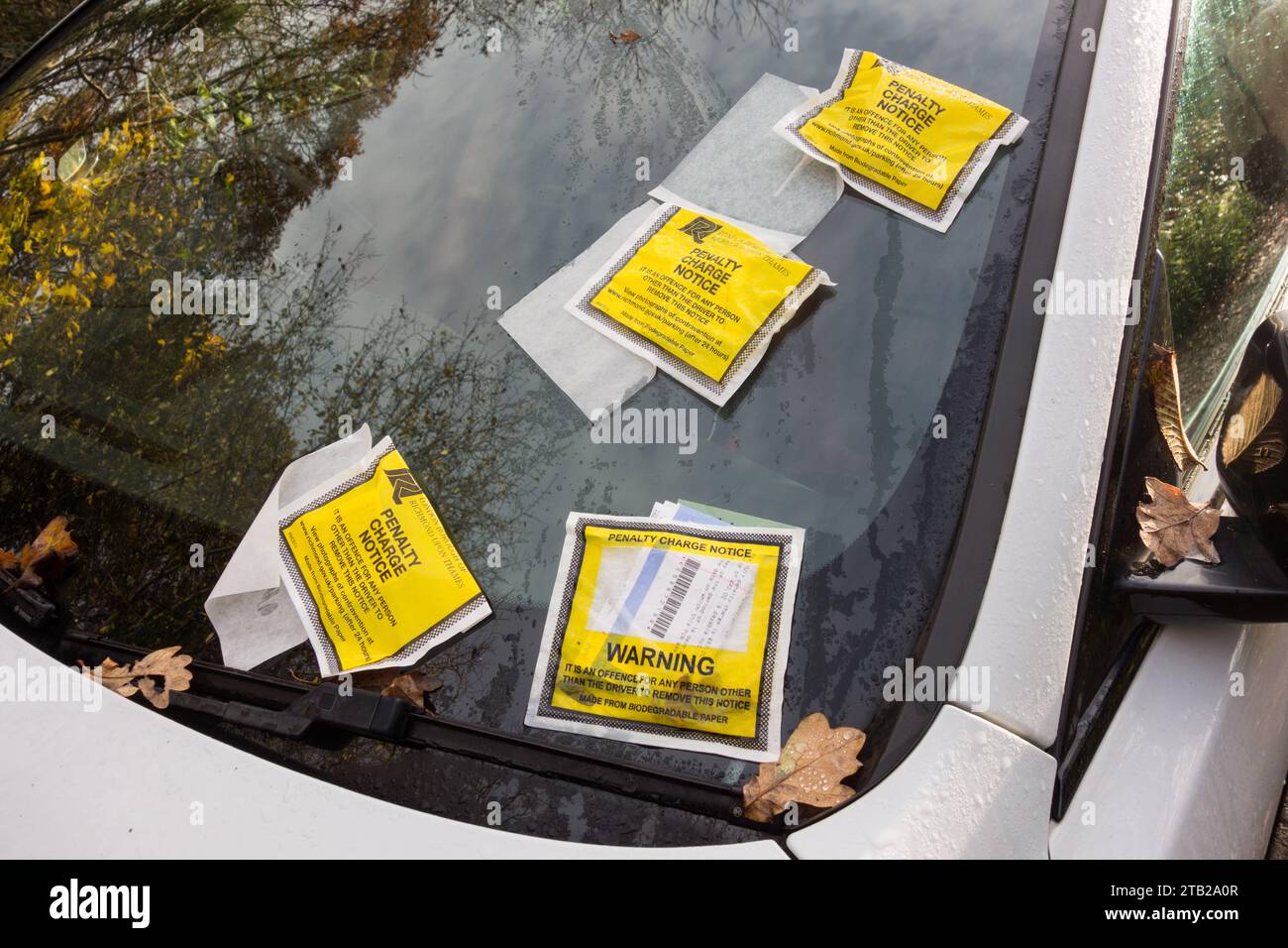 Primo piano di quattro biglietti con preavviso di penalità sul parabrezza di un'auto a Londra, Inghilterra, Regno Unito Foto Stock