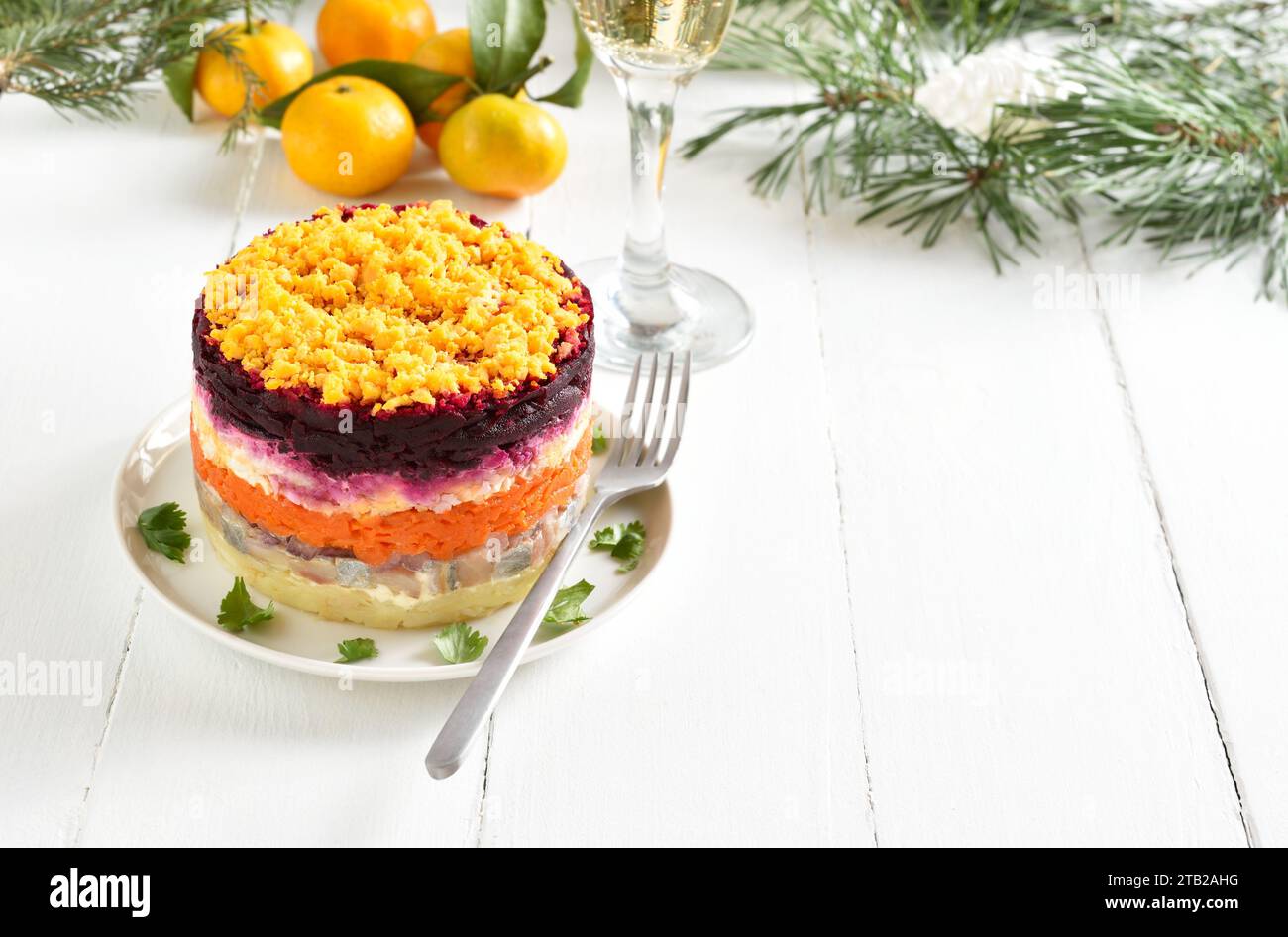 Insalata Shuba. Aringhe vestite, aringhe sotto il cappotto di pelliccia. Insalata di verdure a strati natalizia con aringhe e verdure bollite. Sfondo di legno bianco wi Foto Stock