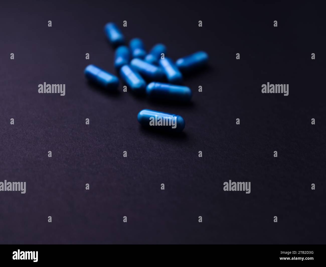 Capsule di aminoacidi su sfondo di carta scura. Messa a fuoco morbida. Primo piano. Copia spazio. Foto Stock