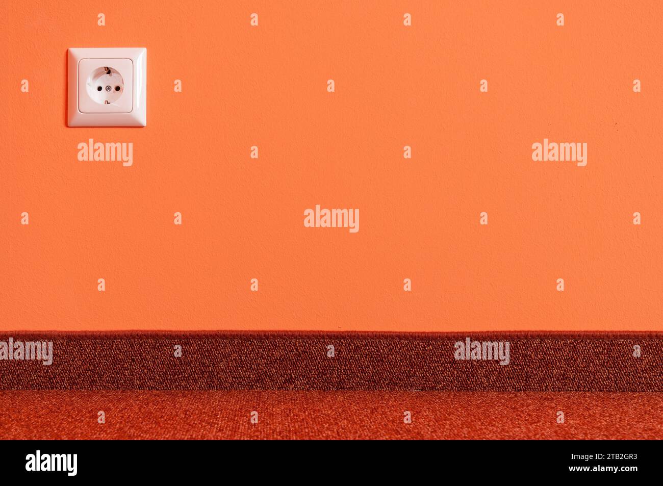 Una presa su un muro arancione in un nuovo edificio Foto Stock