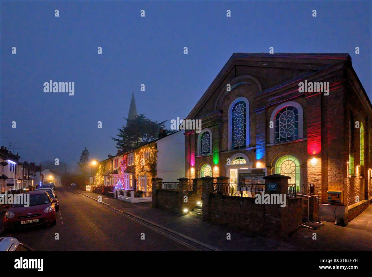 Esher Green Baptist Church e le luci natalizie sulle case. Park Road, Esher, Surrey, Inghilterra. Foto Stock