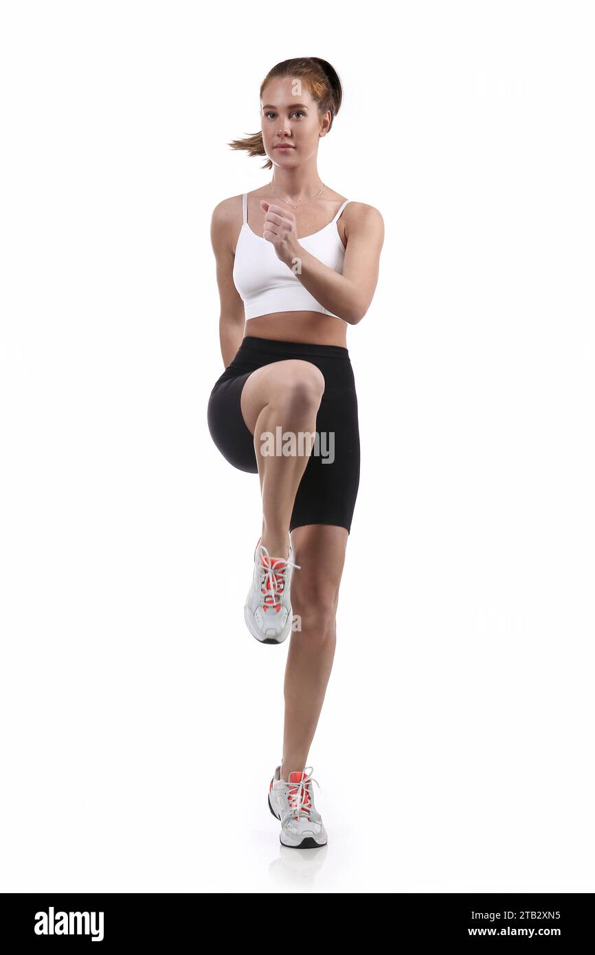 Attraente donna in forma che si allena in studio con copyspace. Immagine di giovane atleta sana che fa esercizio di fitness su sfondo bianco. Foto Stock