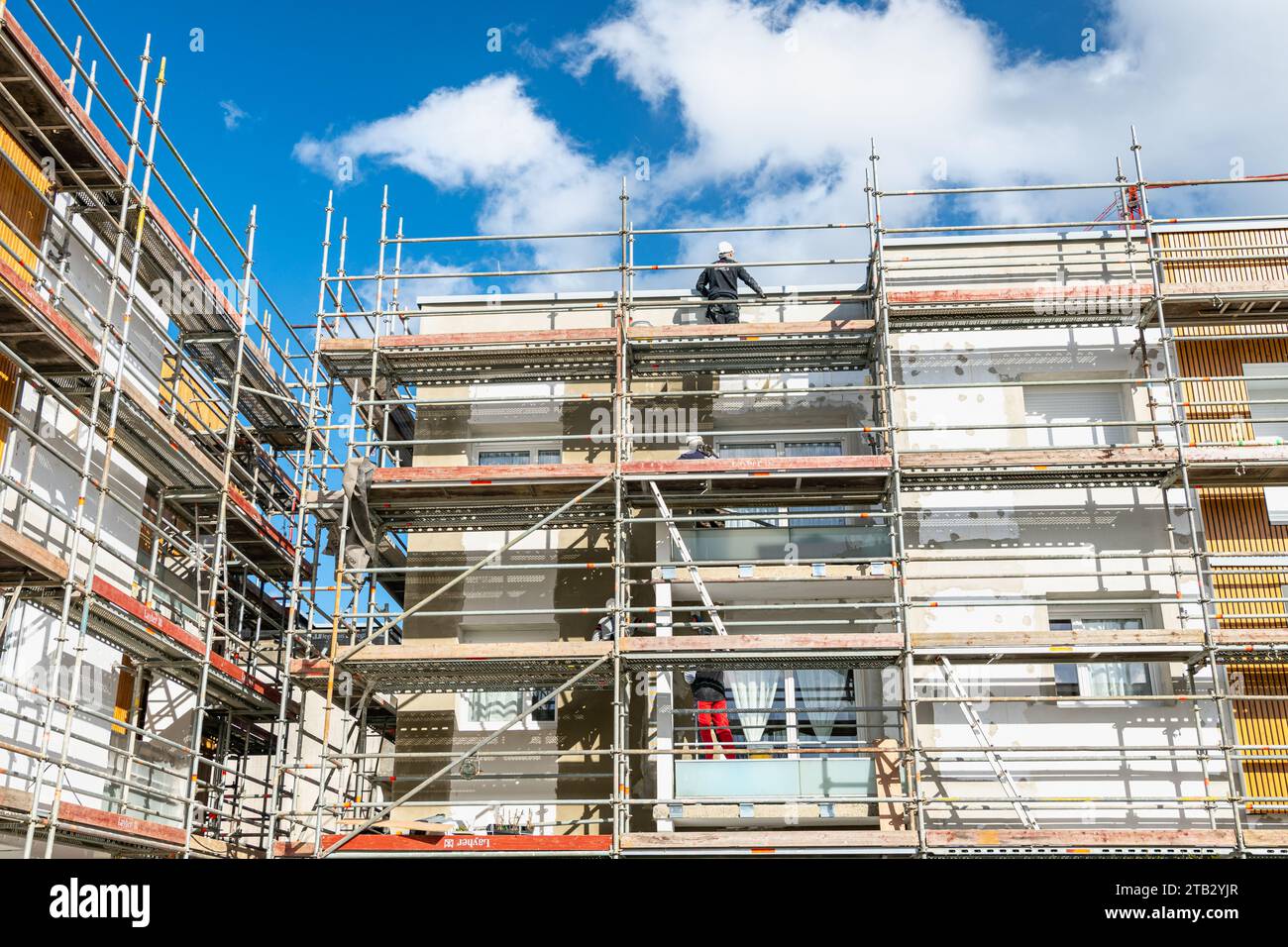 Riabilitazione termica di edifici di appartamenti. Ristrutturazione di facciate con installazione di coibentazioni e rivestimenti. Isolamento parete esterna, energ Foto Stock