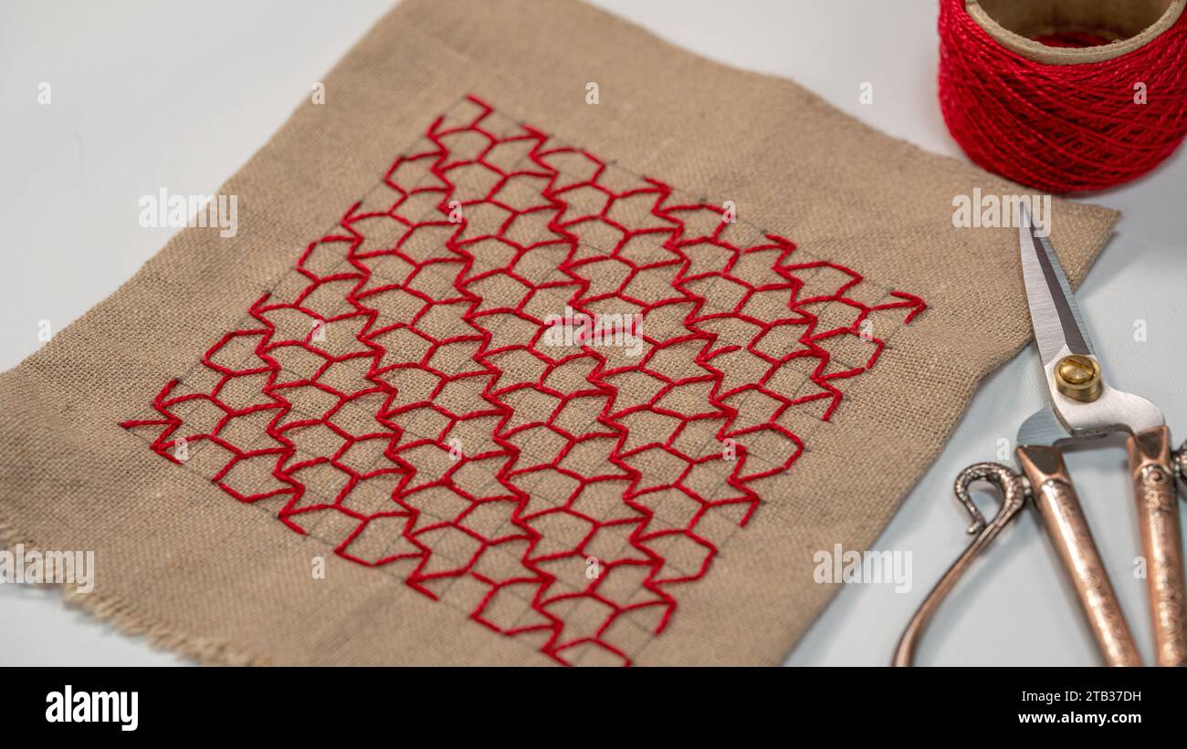 Eleganza artigianale: Motivo marrone cucito a mano su tessuto di cotone Foto Stock