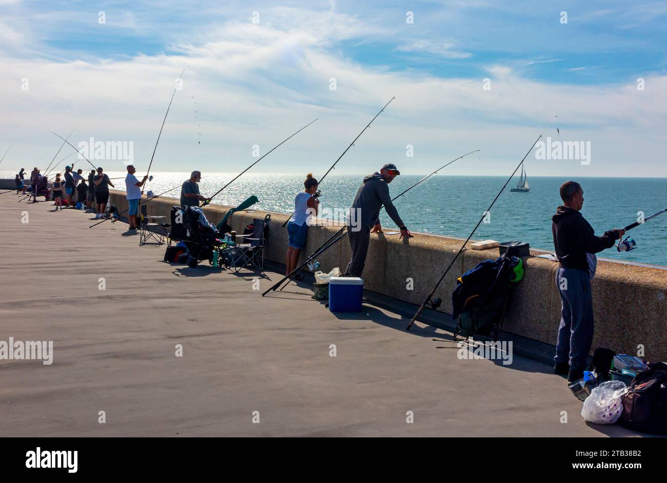 Persone che usano canne per pescare sul molo del porto di Folkestone Kent Inghilterra Regno Unito con cielo blu sopra. Foto Stock