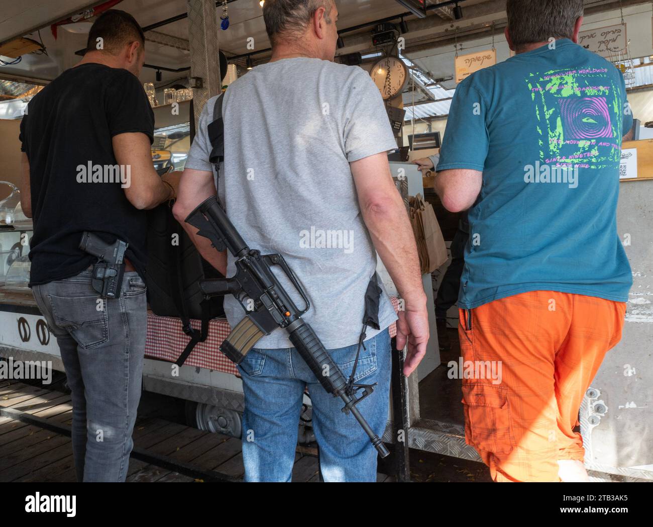 Shoresh, Israele. 4 dicembre 2023. Civili israeliani con le loro armi personali, sia un fucile d'assalto M-16 che una pistola, in un caffè a Shoresh, in Israele, il 4 dicembre 2023. Molti israeliani, sia soldati che civili, stanno portando con sé le loro armi mentre la guerra continua contro Hamas nella Striscia di Gaza e combattono attacchi ovunque si verifichino all'interno di Israele, come l'attacco a una fermata dell'autobus di Gerusalemme qualche giorno fa, che è stato fatto dai sostenitori di Hamas da Gerusalemme Est. Foto di Jim Hollander/UPI Credit: UPI/Alamy Live News Foto Stock