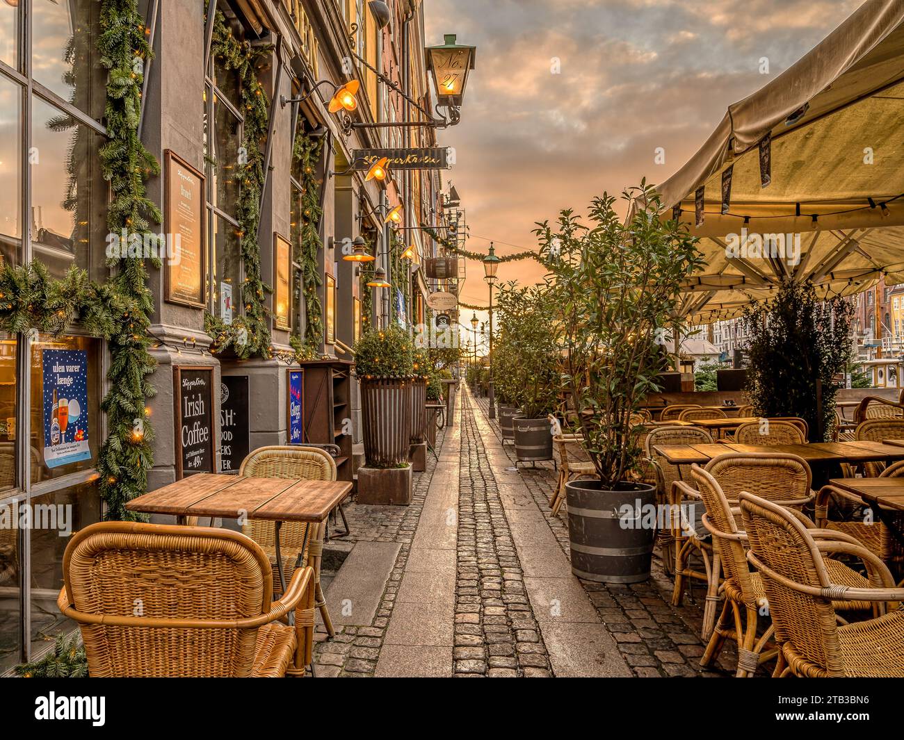 Passeggia tra i ristoranti colorati sul molo del canale di Nyhavn a Copenaghen, 25 novembre 2023 Foto Stock